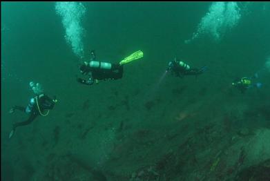 looking down at divers at base of wall